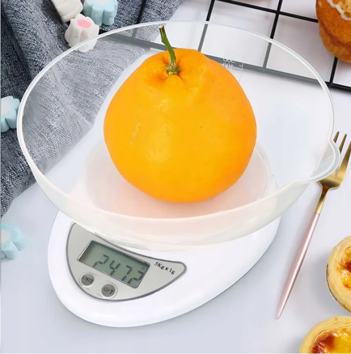 waga kuchenna biała z miseczką z owocami w środku